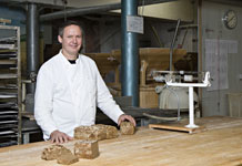 Thomas Effenberger und seine herzhaften Vollkornbrote, traditionell 
gebacken aus Zutaten wie vor 1000 Jahren � frisch gemahlenes 
Getreide, Sauerteig, Wasser, Meersalz. 
Foto: Henning Angerer
(46 x 31 cm)